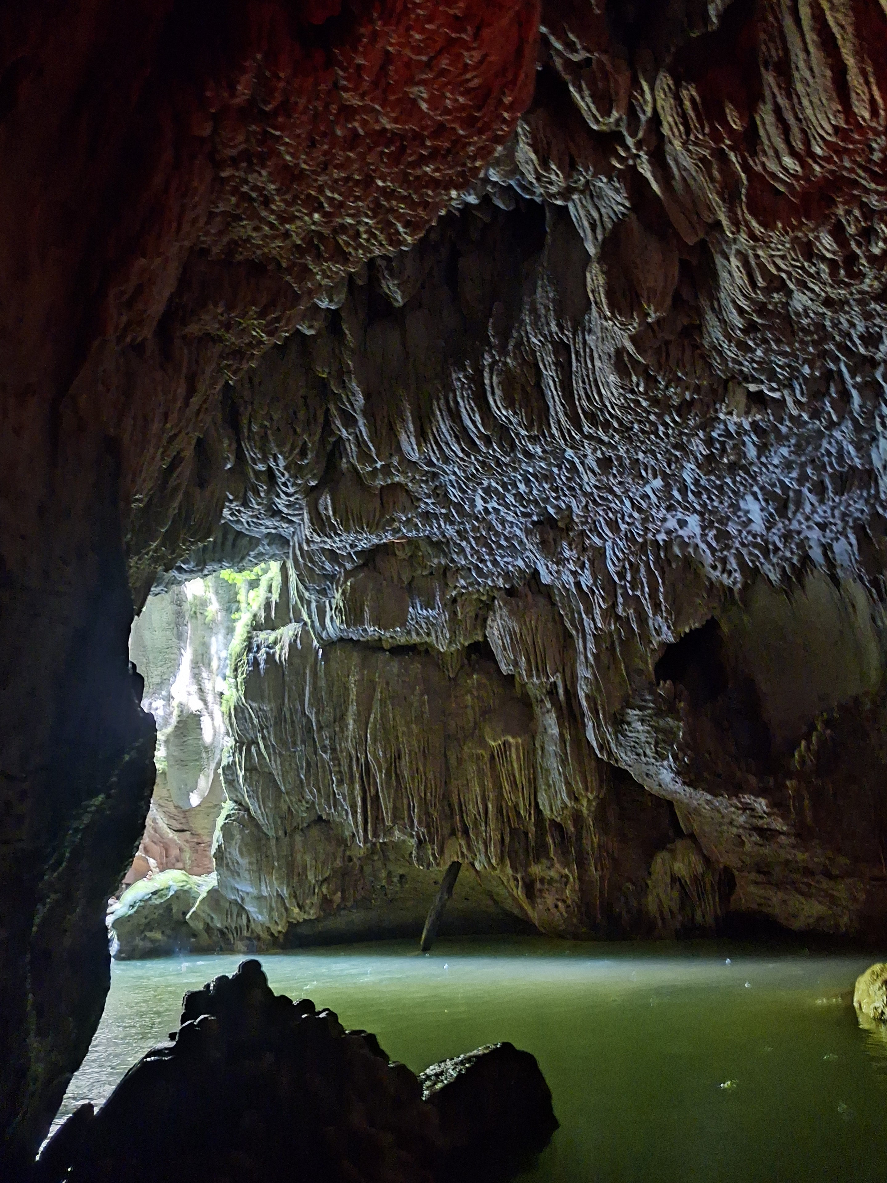 Dramatic cave ceiling with stalactites and a beam of light