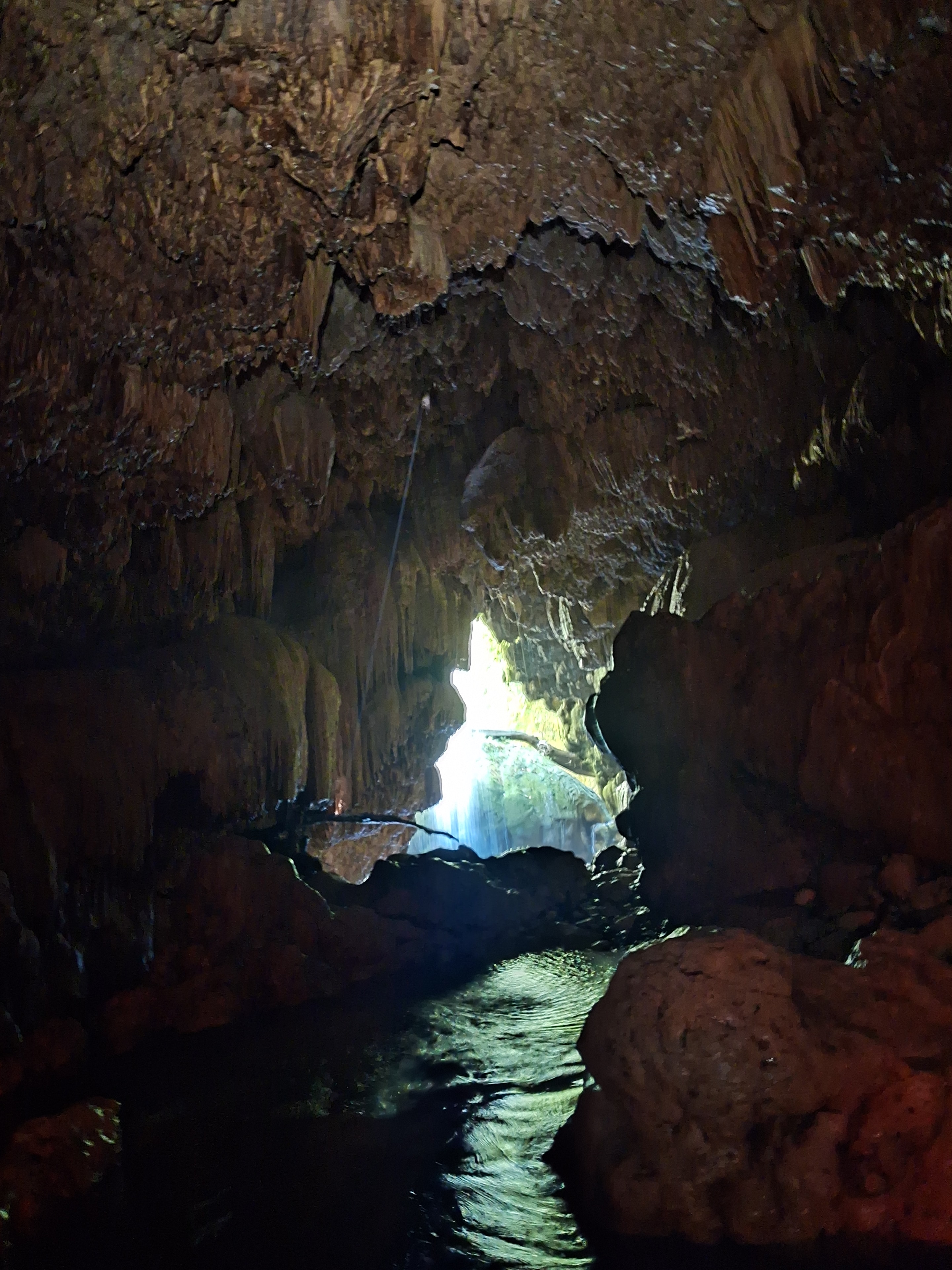 Cave tunnel with light streaming through the opening