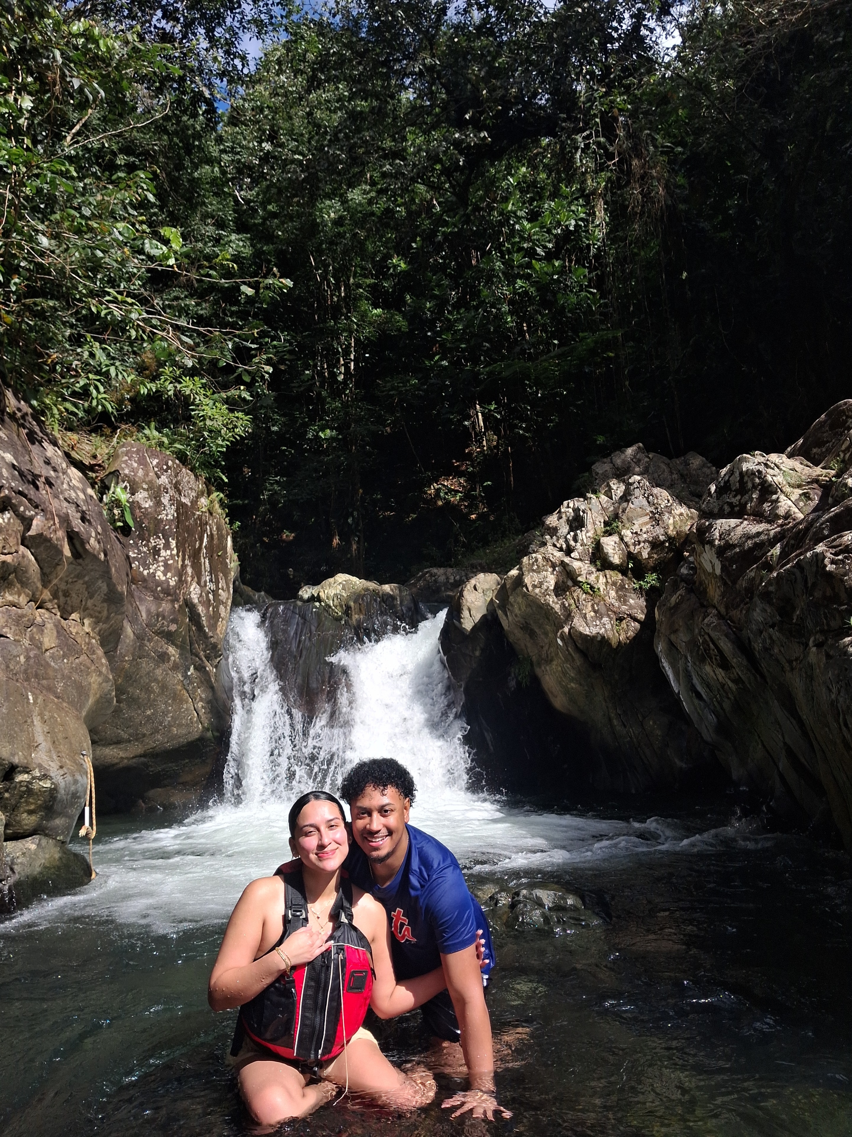 Couple posing at a waterfall in the rainforest