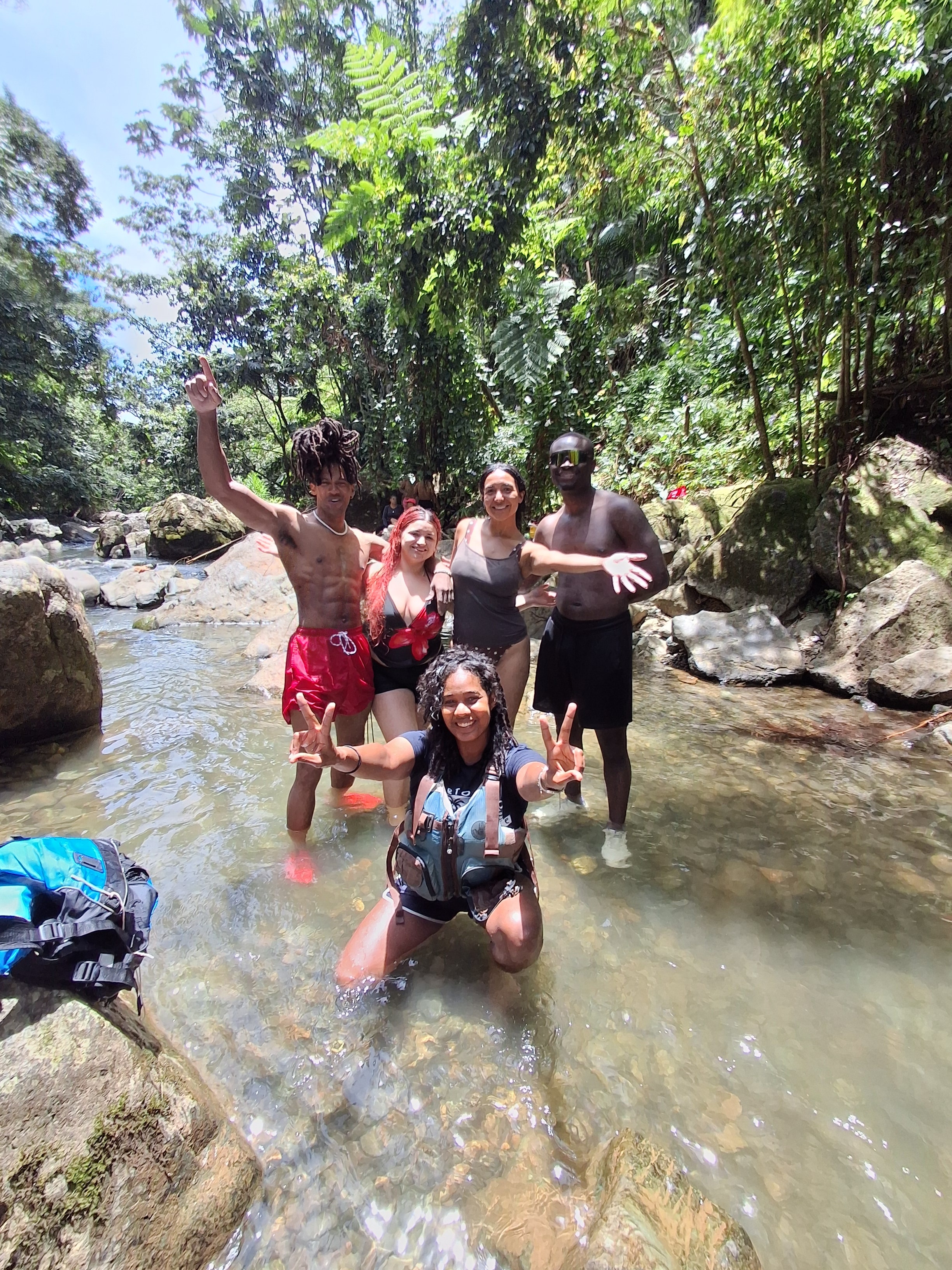 Group of friends celebrating in a jungle river