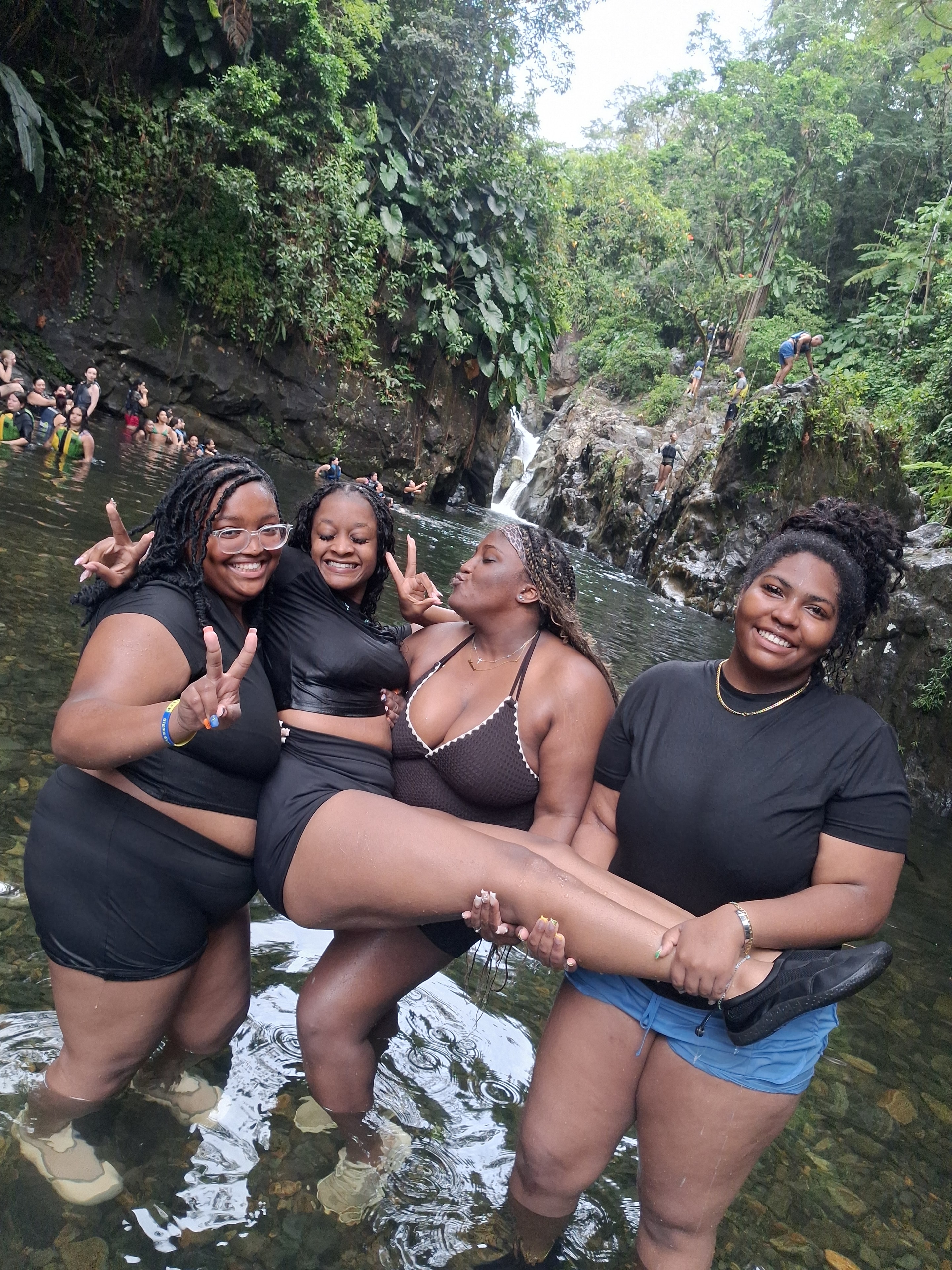 Three friends celebrating at the waterfall pool