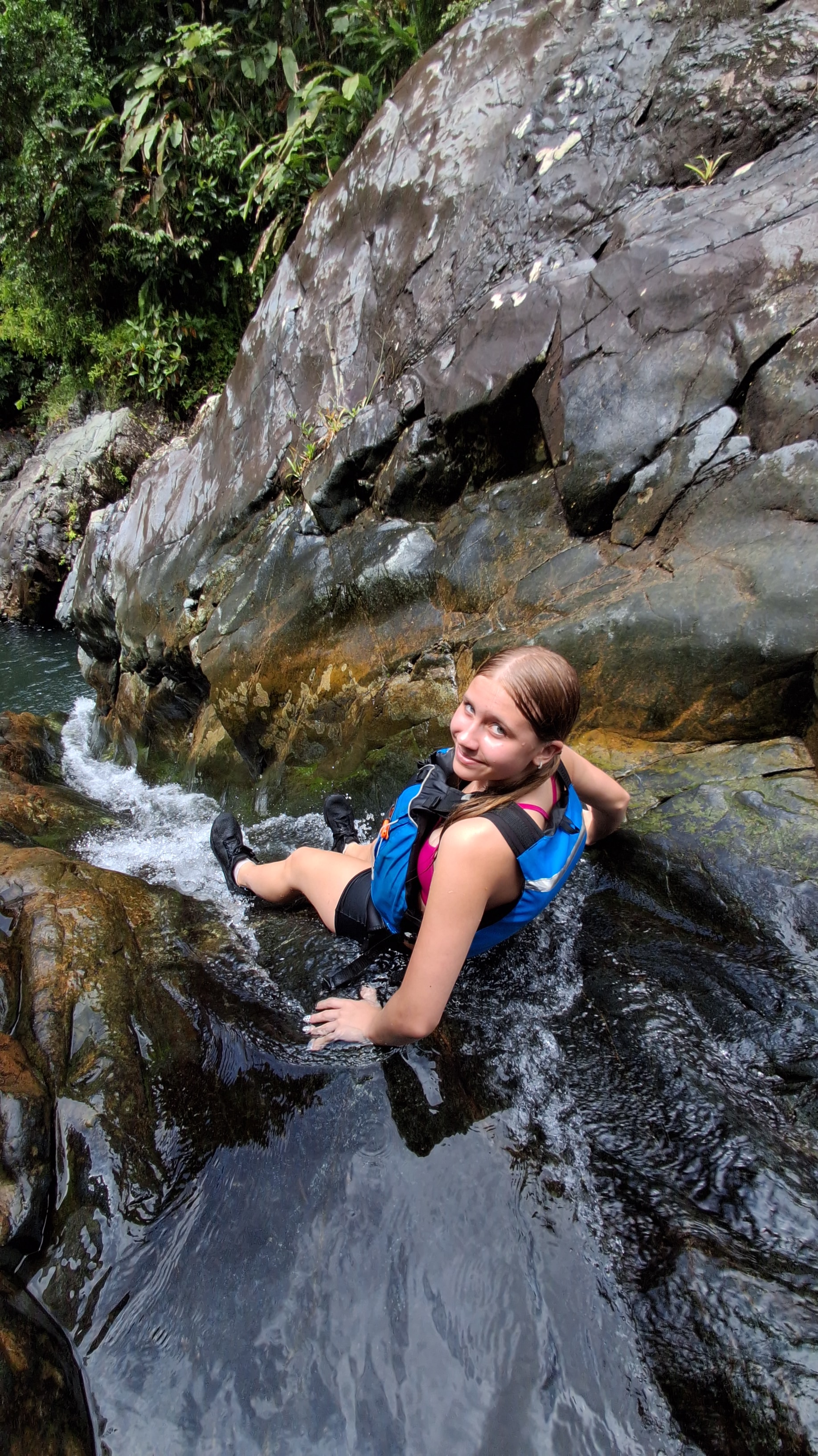 Guest navigating the rocky waterfall with a smile
