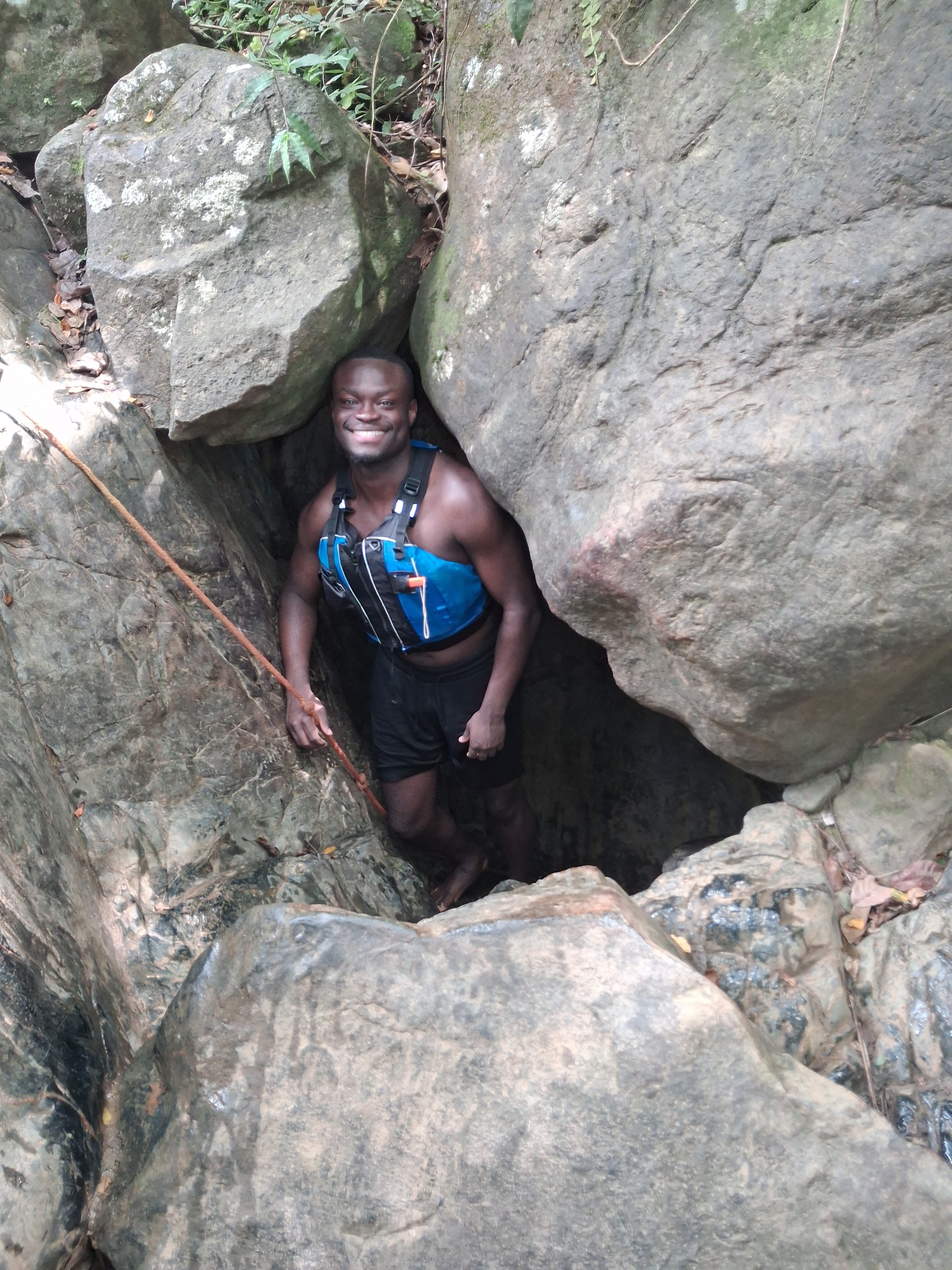Guest squeezing through a rock crevice on the trail